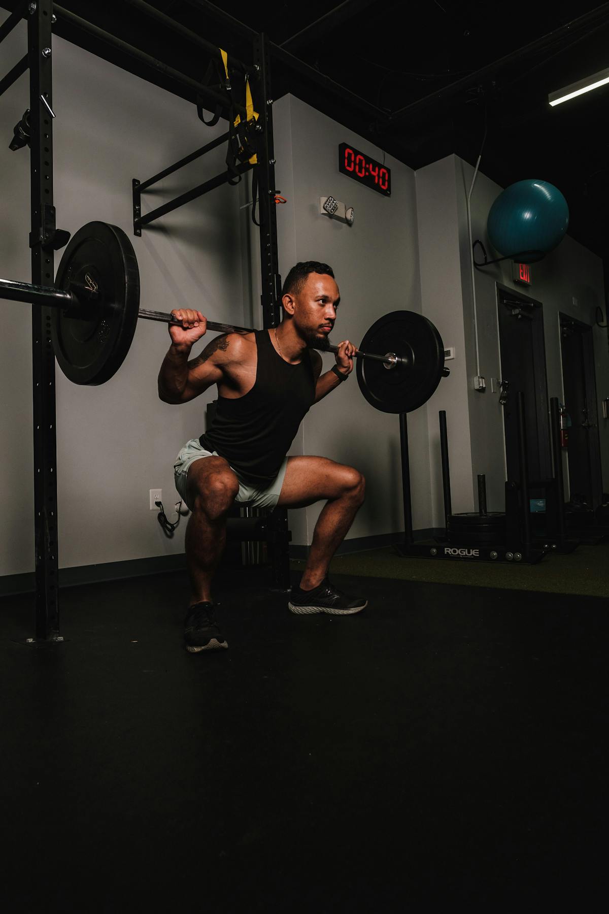 Member loading a barbell squat at Burn Room